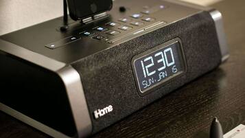 A digital clock displaying 12:30 on a black device with a phone dock.