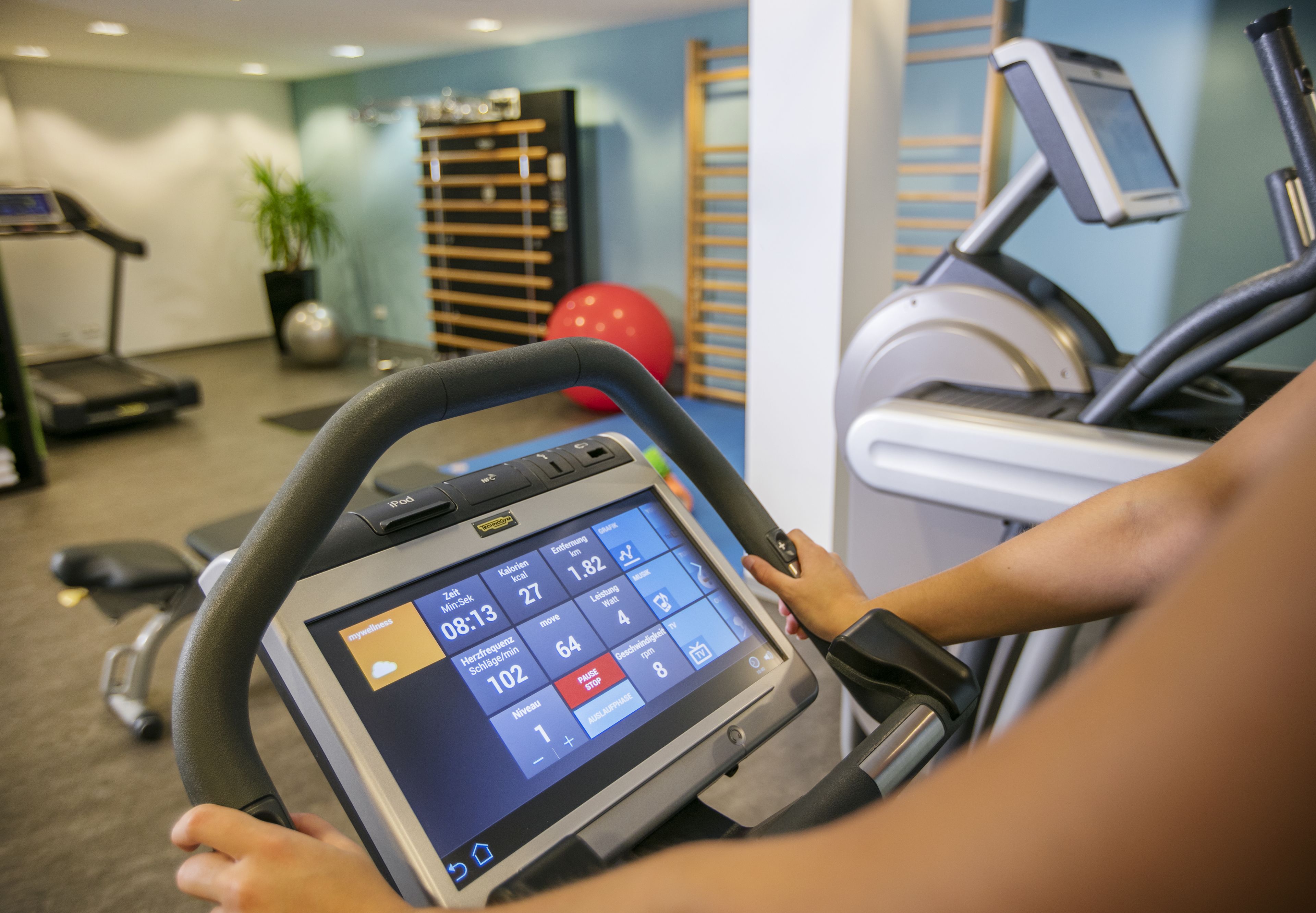 Un gimnasio con equipo de ejercicio, incluyendo una cinta de correr y una máquina elíptica.