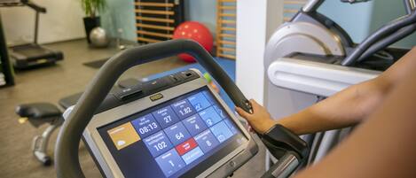 Una palestra con attrezzature per esercizi, tra cui un tapis roulant ed un ellittica.