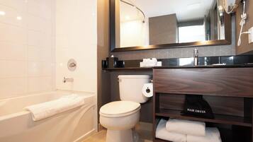 A modern bathroom with a bathtub, toilet, and vanity.