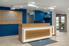 Un mostrador de recepción con detalles de madera y un fondo de pared azul.