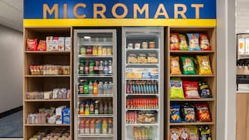 Un Micromart con estantes llenos de aperitivos, bebidas y otros productos de alimentación.