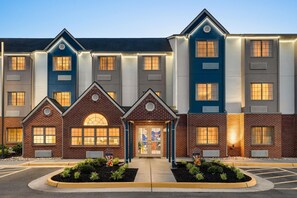 A multi-story hotel with a brick facade, large windows, and a central entrance with a glass door. - Microtel Inn & Suites by Wyndham Culpeper (Culpeper)