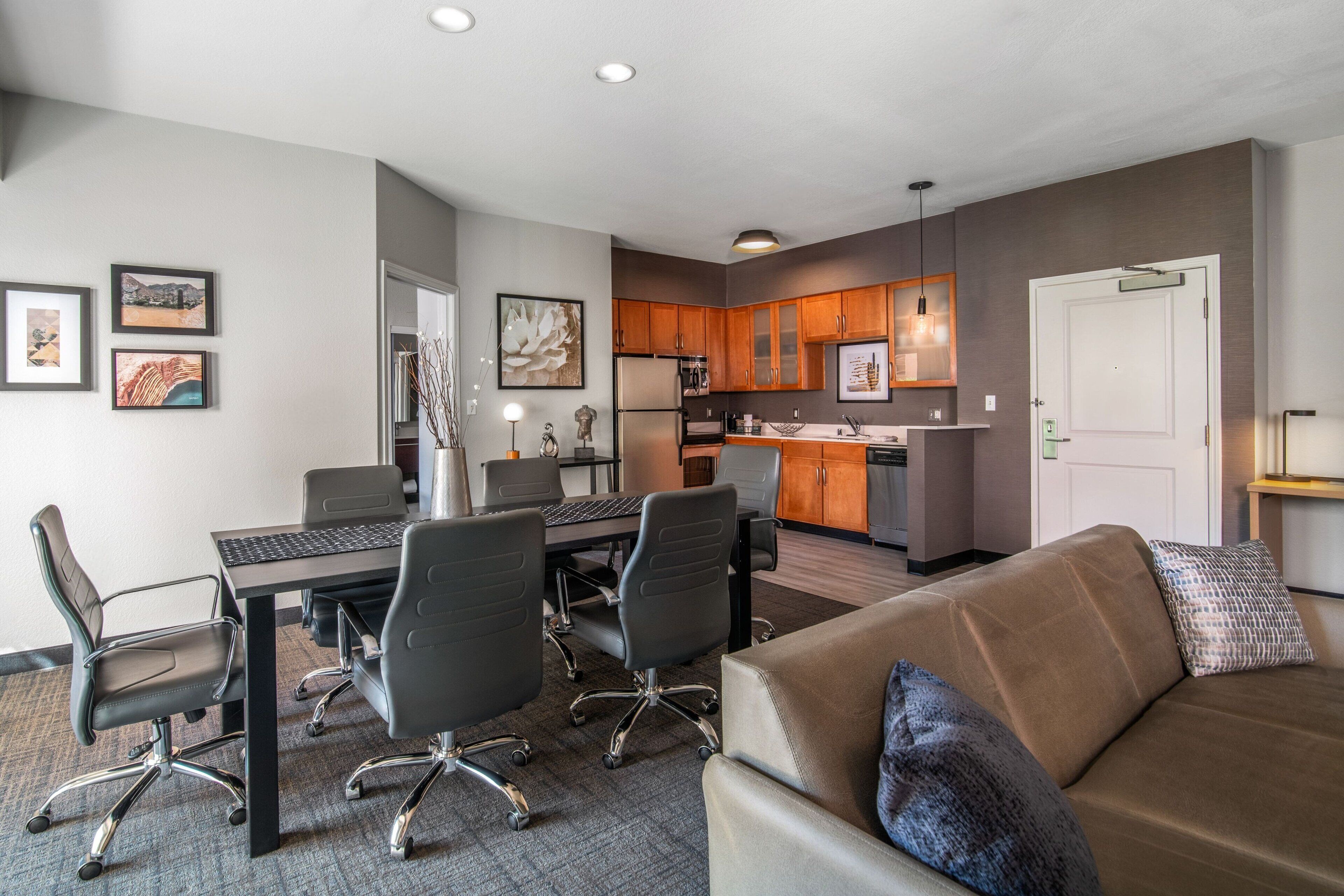 A modern apartment with a dining area, kitchen, and living room.