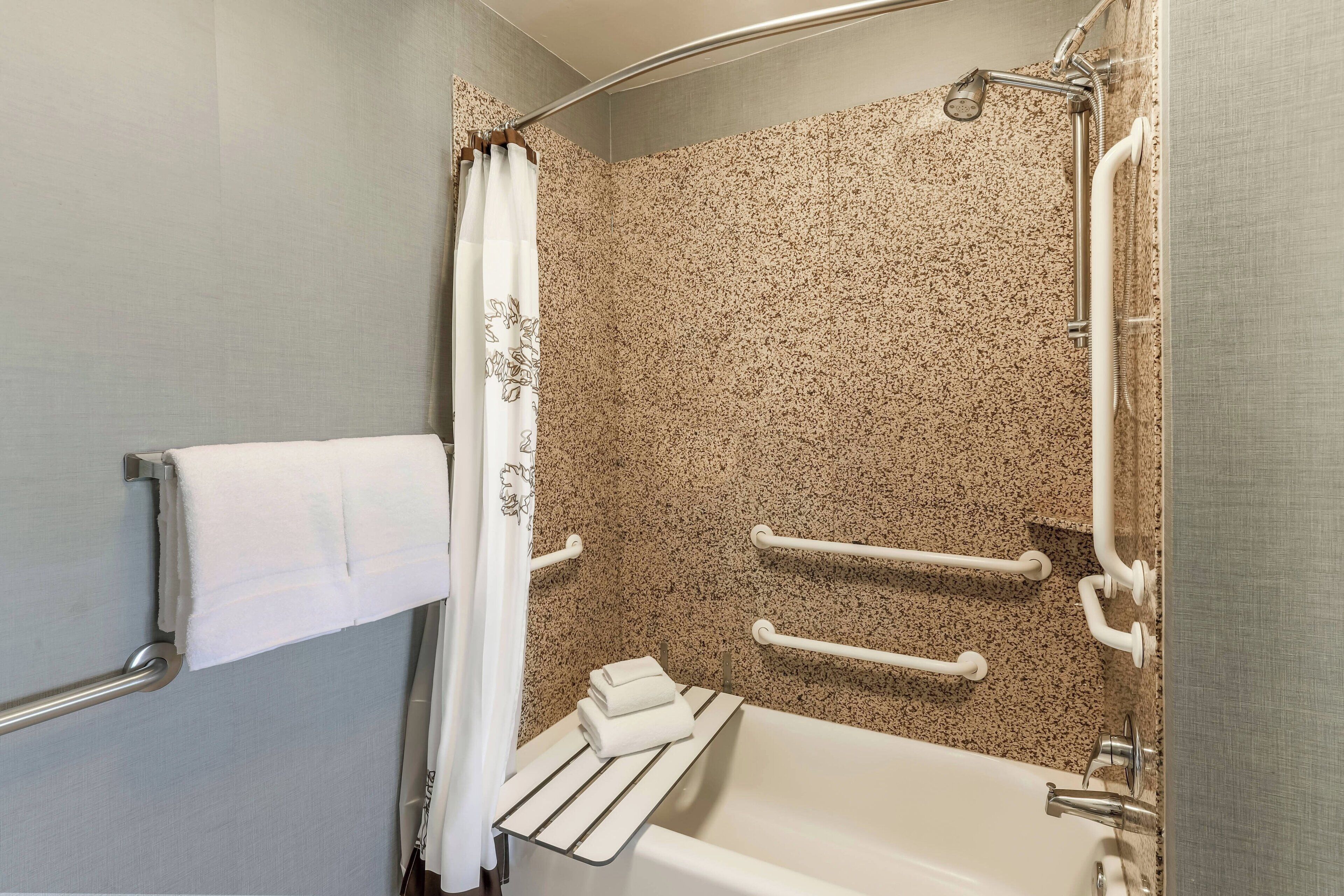 Une salle de bain avec une baignoire, une douche et un porte-serviettes.