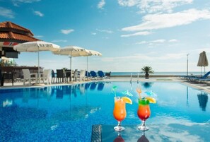 Een seizoensgebonden buitenzwembad, parasols voor strand/zwembad