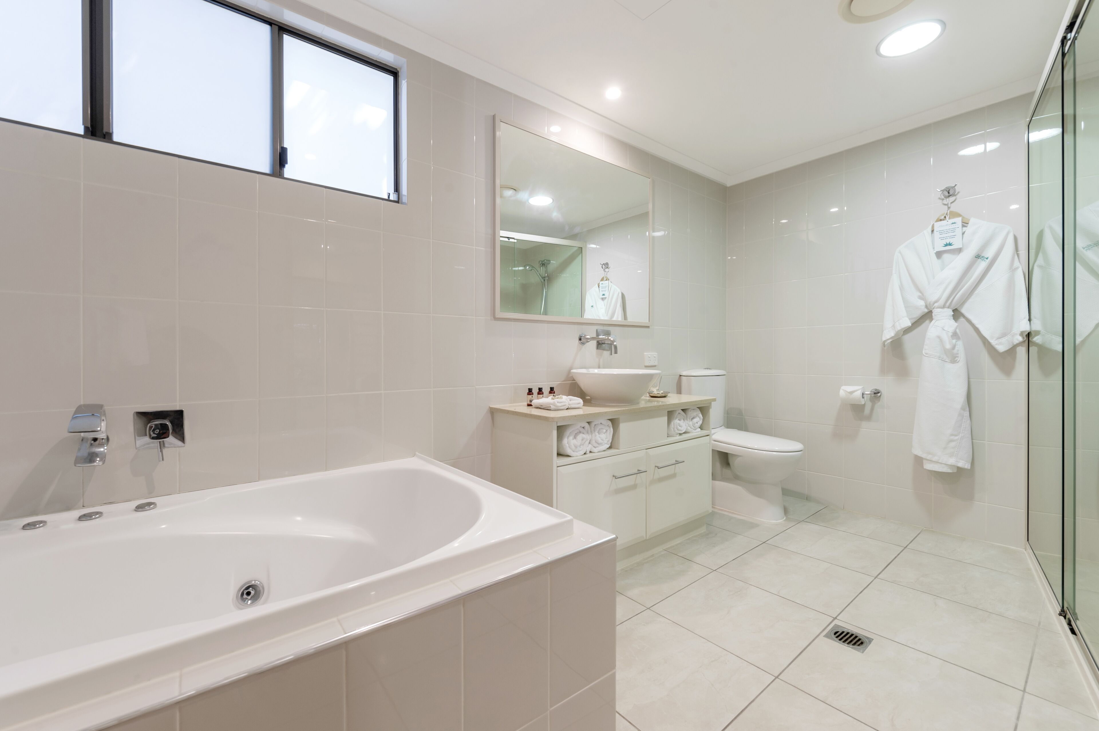 A modern bathroom with a bathtub, sink, and toilet.