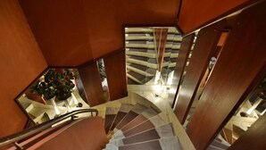 A spiral staircase with a modern design, featuring a combination of wooden and metal elements. - Boutique Hotel KRISTOFS (Riga)