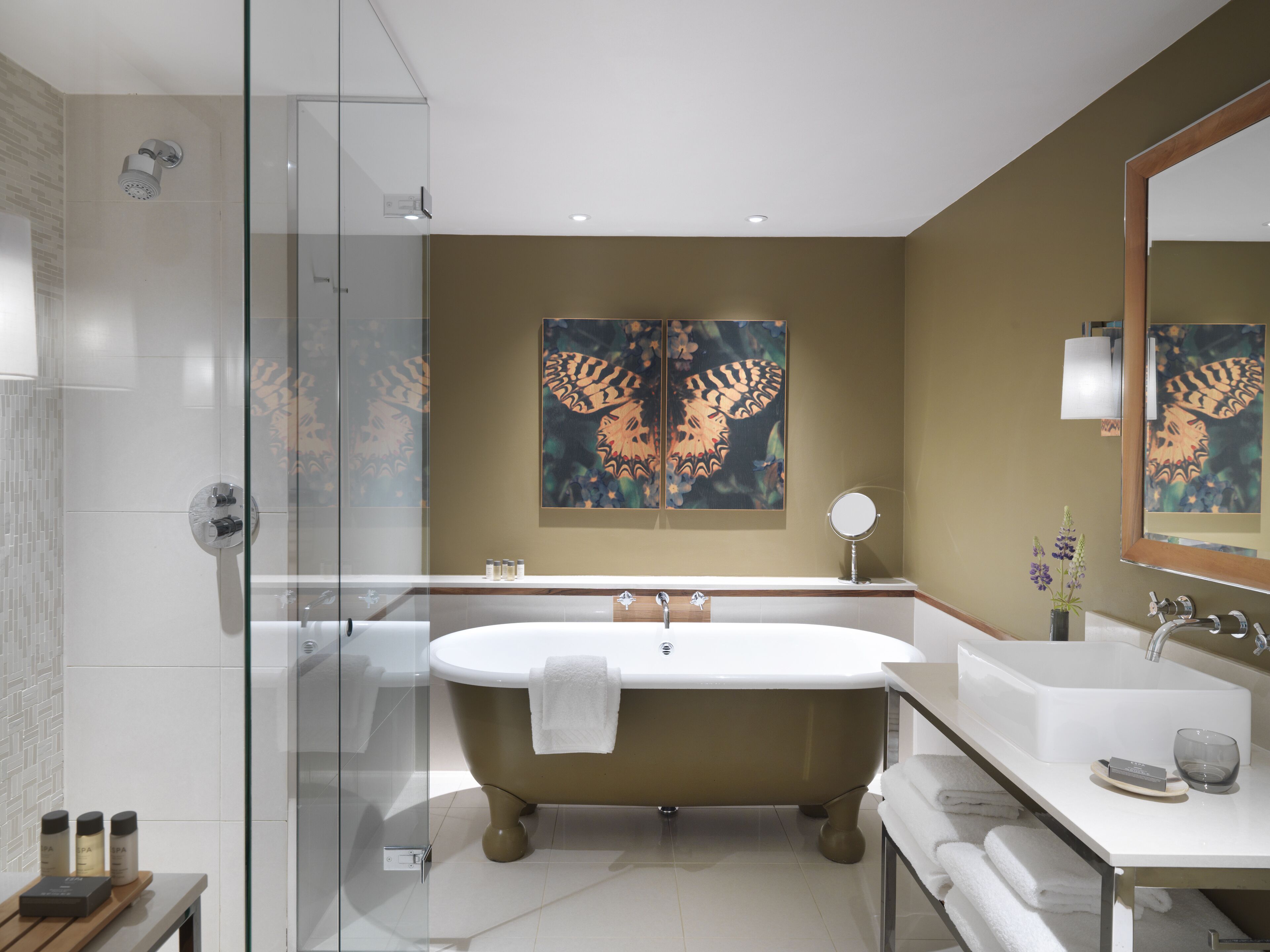 A modern bathroom with a freestanding bathtub, a glass-enclosed shower, and a large mirror.