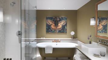 A modern bathroom with a freestanding bathtub, a glass-enclosed shower, and a large mirror.