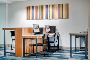 A modern office space with a wooden desk, two computer monitors, and a striped artwork on the wall. - Holiday Inn Express Hotel & Suites Tappahannock by IHG (Tappahannock)