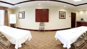 A conference room with two tables, a chair, and framed pictures on the walls. - Holiday Inn Express Hotel & Suites Tappahannock by IHG (Tappahannock)