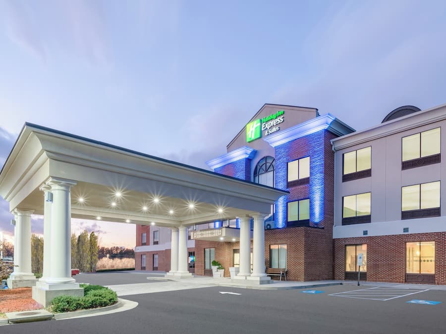 Un Holiday Inn Express & Suites con entrada cubierta, aparcamiento y fachada de ladrillo.