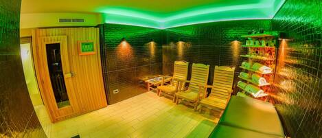 A spa room with wooden chairs, a massage table, and a small table with a book.