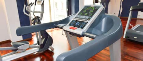 A gym with a treadmill, exercise bike, and elliptical machine.