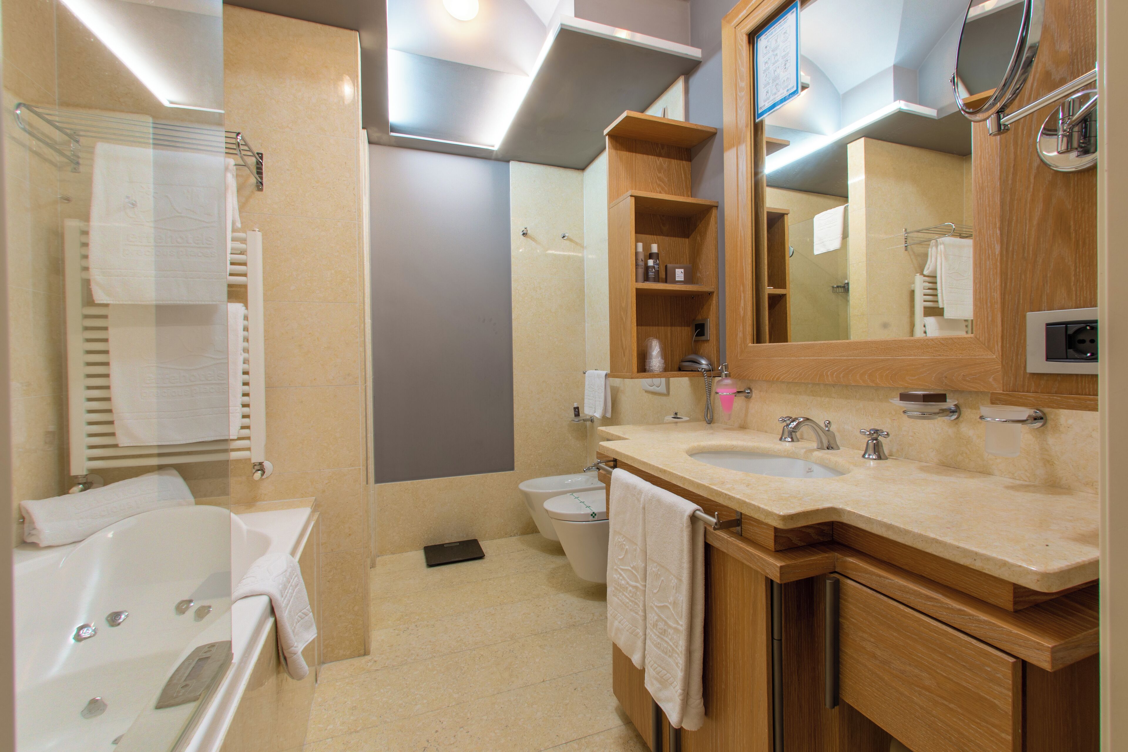 A modern bathroom with a bathtub, sink, and toilet.