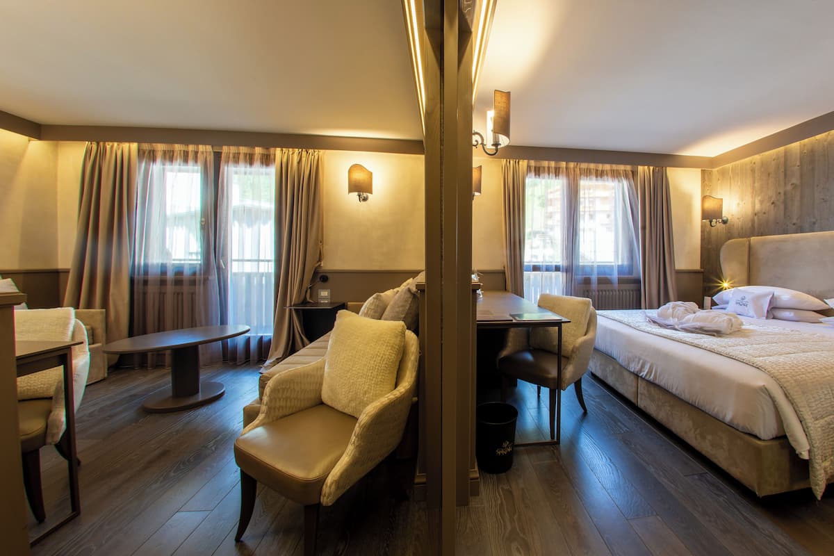 Ein Hotelzimmer mit Bett, Schreibtisch, Stuhl und Tisch.