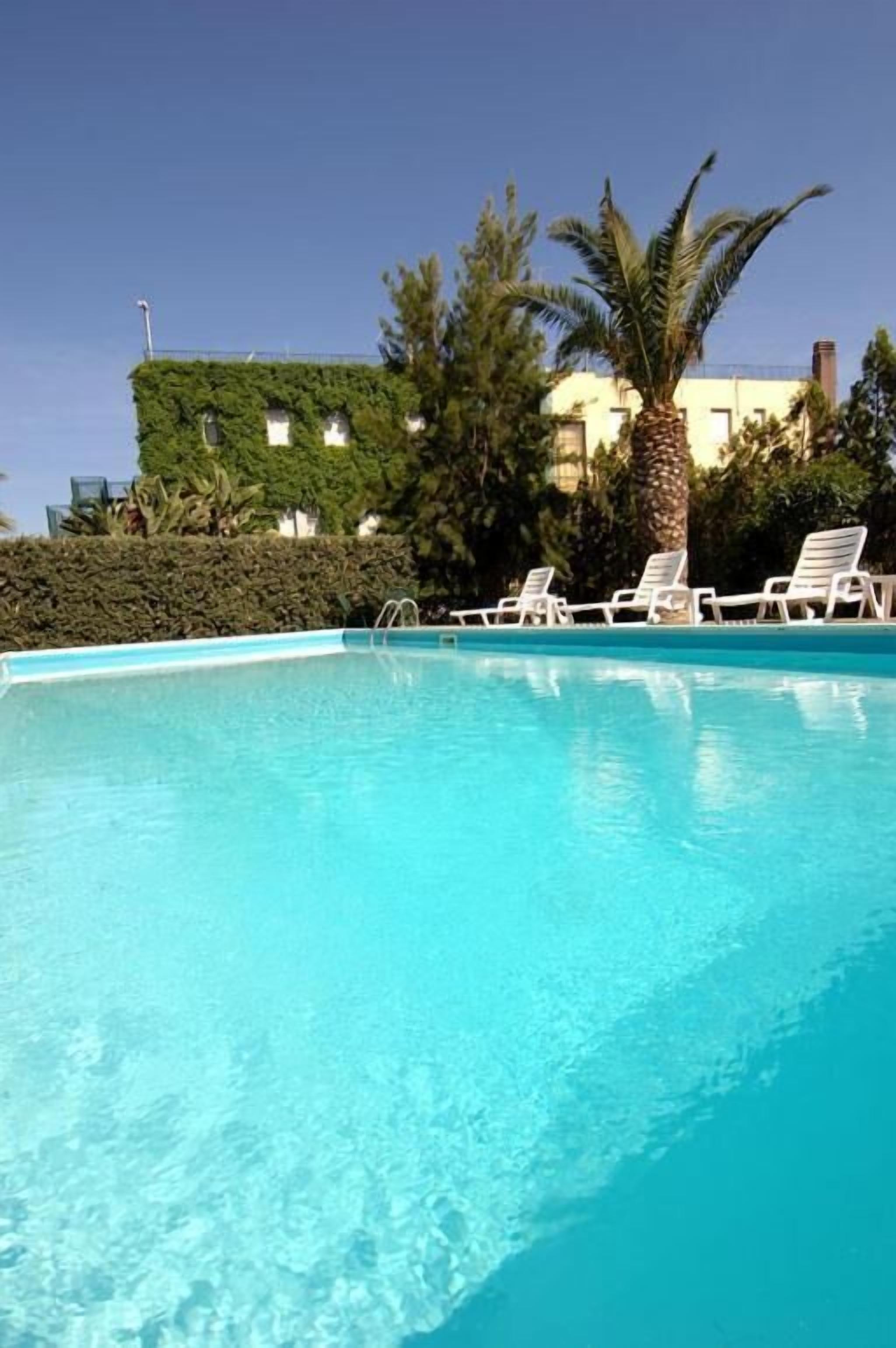 Piscine extérieure, parasols de plage, chaises longues