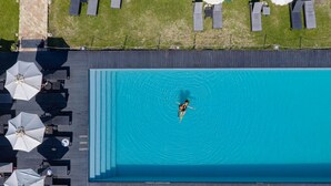 An aerial view of a swimming pool with lounge chairs and umbrellas around it. - Falconara Greenblu Resort (Butera)