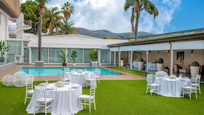 A poolside area with multiple round tables set for dining, surrounded by white chairs. - Hotel I Gigli (Nola)