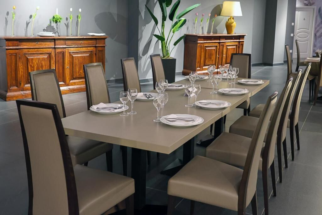A dining area with a long table set for a meal, surrounded by chairs.