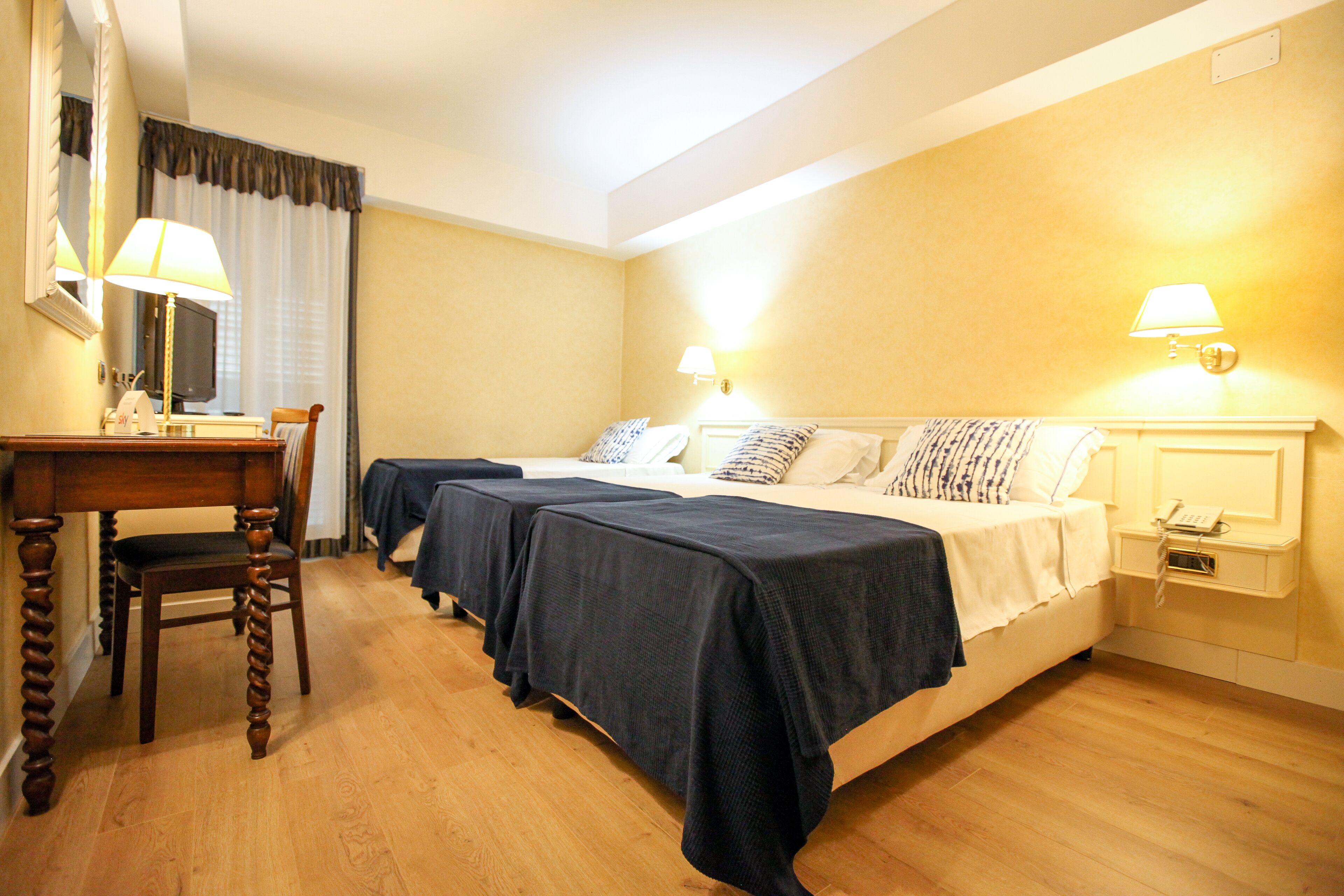 Una habitación de hotel con dos camas, un escritorio y una silla.