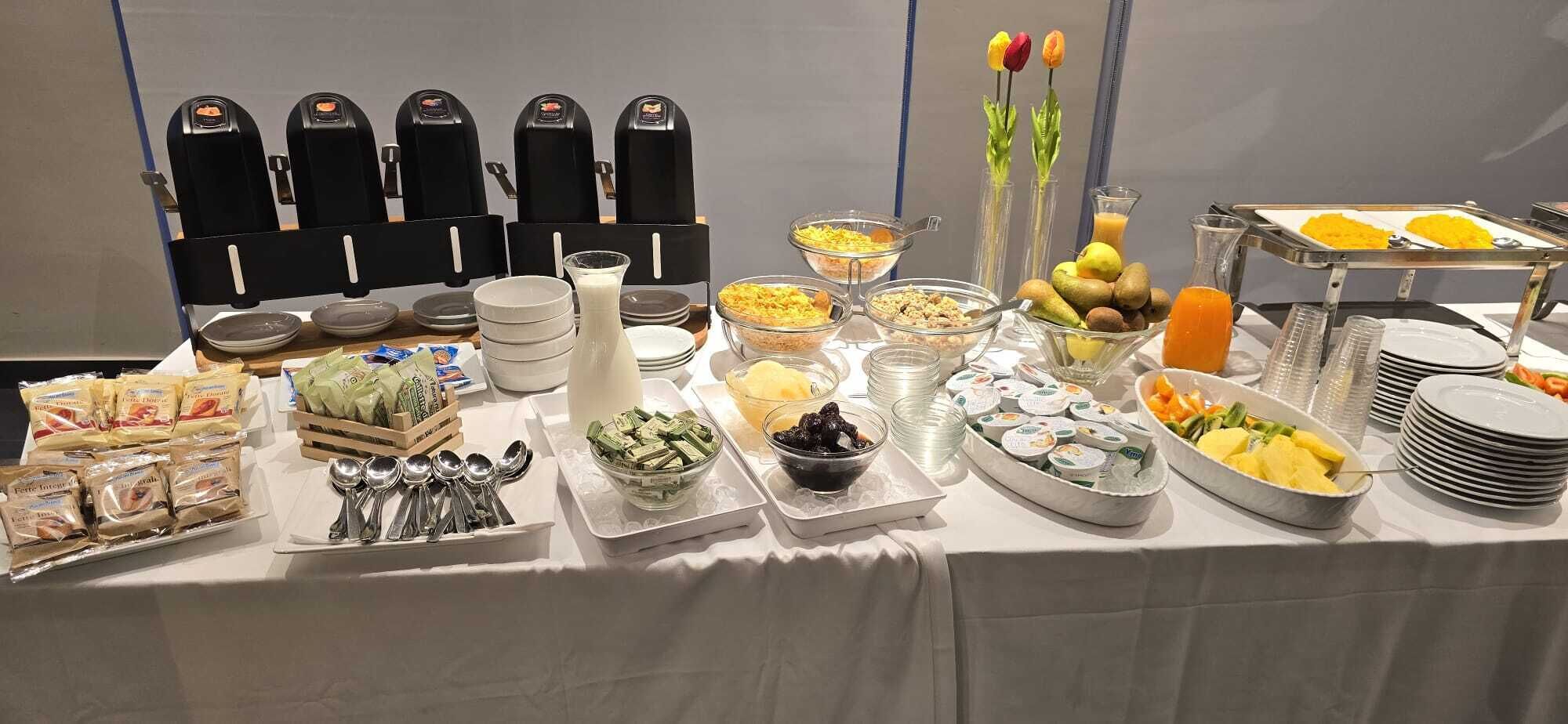 A buffet table with various food items, including fruits, cereals, and dairy products.
