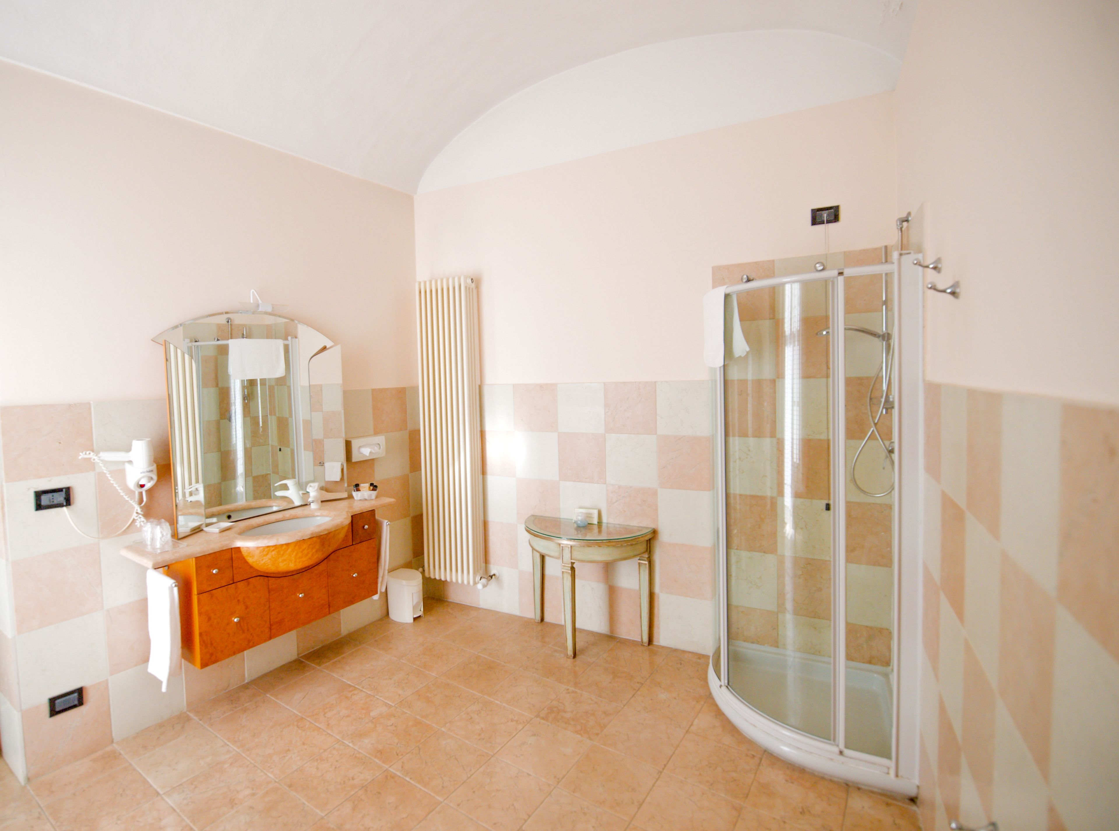 Ein Badezimmer mit Waschtisch, Spiegel, Dusche und Toilette.