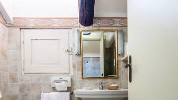 A bathroom with a pedestal sink, a bidet, a toilet, and a mirror.