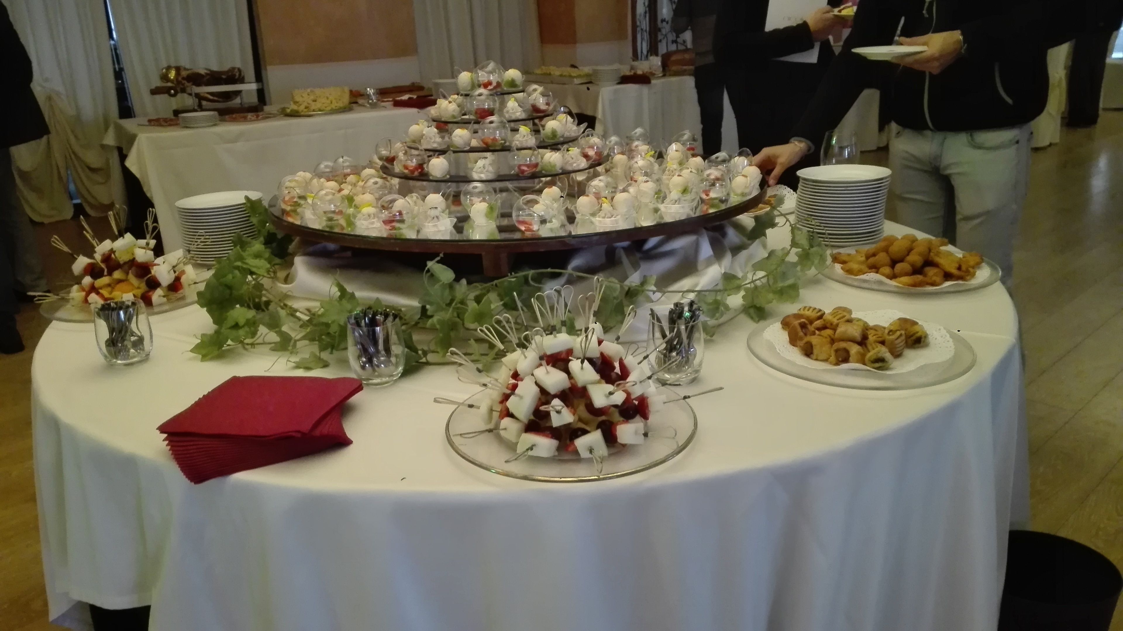 Ein reichhaltiges Buffet mit verschiedenen Speisen, darunter Spieße, Gebäck und einer mehrstöckigen Dessertauslage.