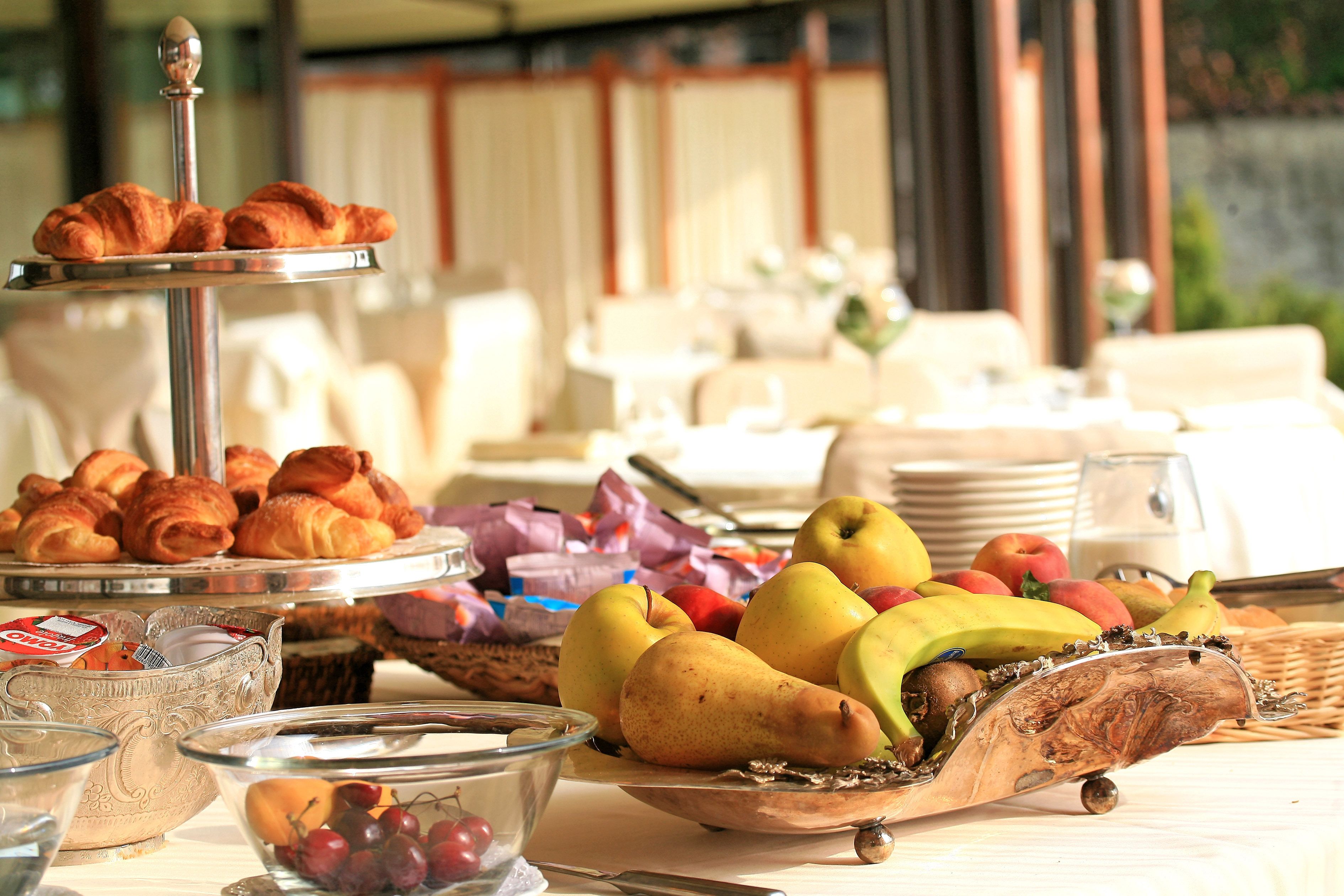 Ein Frühstücksbuffet mit Gebäck, Früchten und einer dekorativen Holzschüssel.