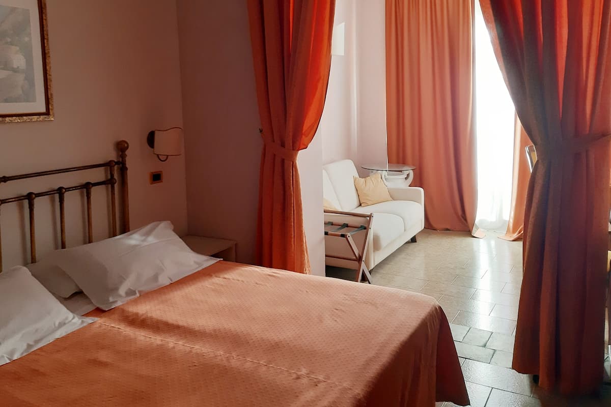 A bedroom with a bed, a chair, and a table.