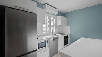 A modern kitchen with a refrigerator, microwave, dishwasher, and oven.