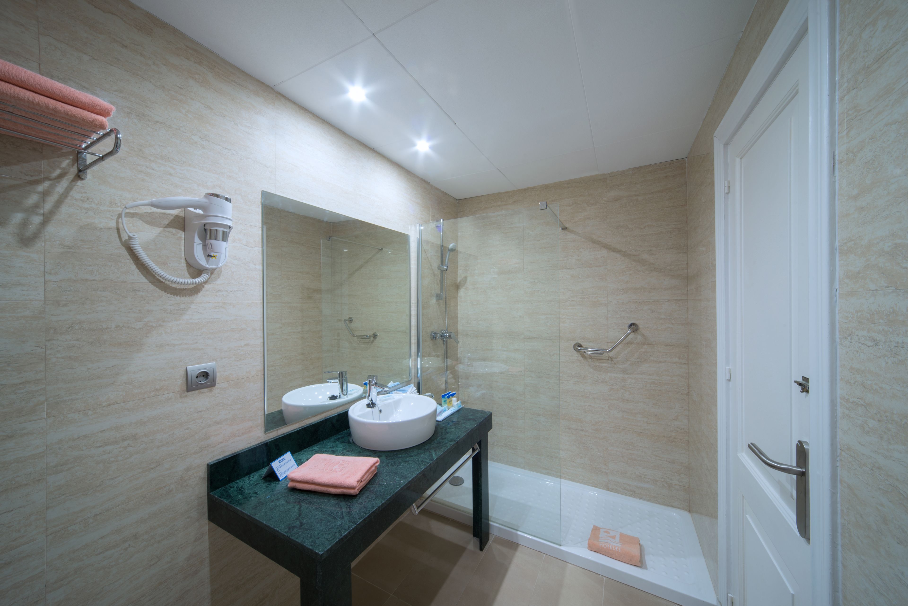 Un baño moderno con lavamanos doble, un espejo grande, cabina de ducha de vidrio y una bañera.