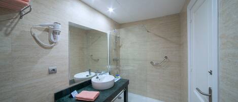 Un baño moderno con lavamanos doble, un espejo grande, cabina de ducha de vidrio y una bañera.