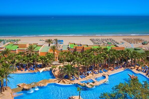 A resort with multiple swimming pools, palm trees, and a beach view. - Playacapricho Hotel (Roquetas de Mar)