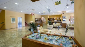 A spacious lobby with a reception desk, seating area, and a decorative aquarium. - Hotel Salinera - Sava Hotels & Resorts (Piran)