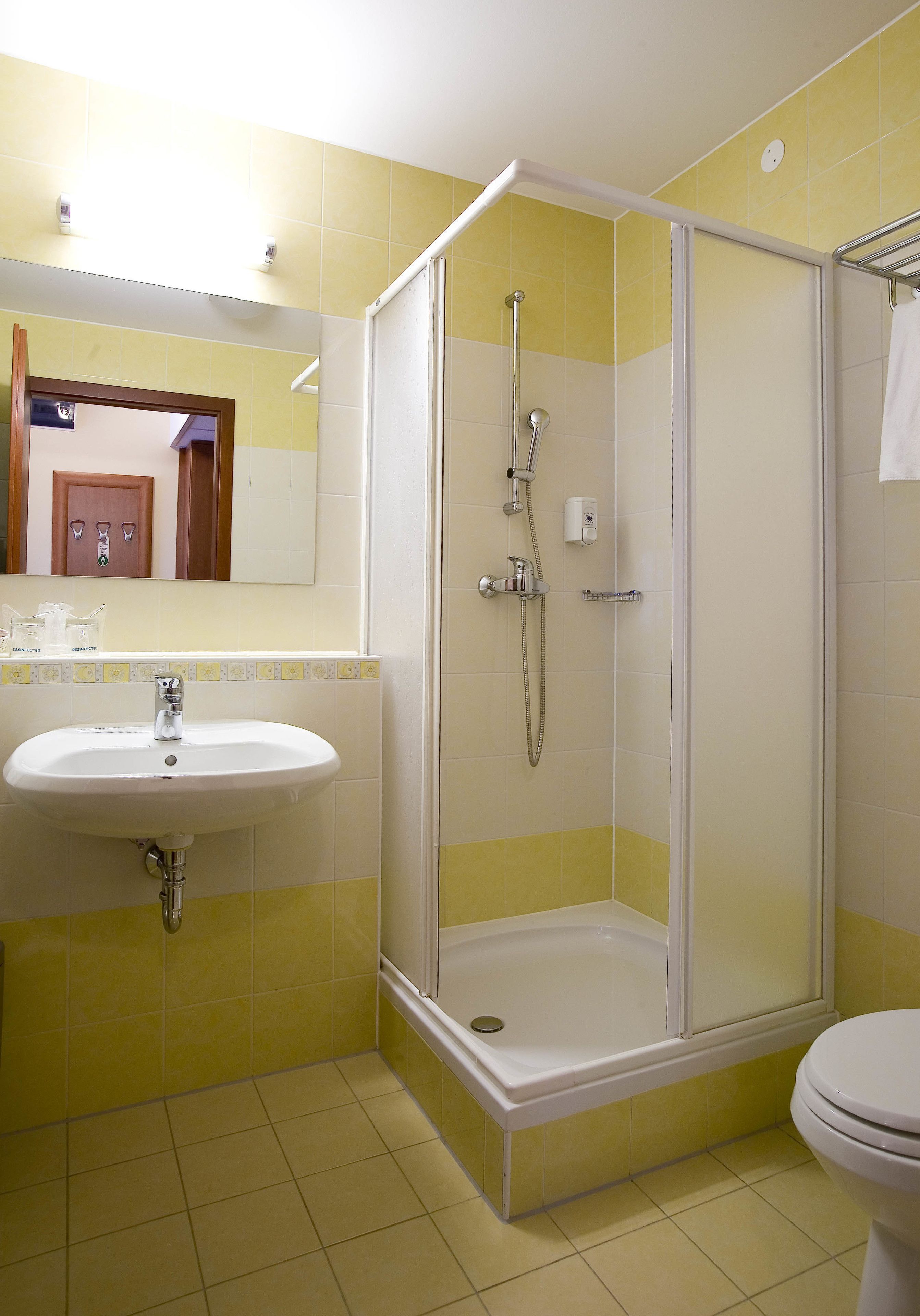 A bathroom with a shower, sink, and toilet.