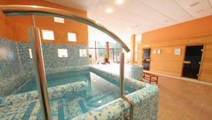 An indoor swimming pool with blue mosaic tiles, a glass barrier, and wooden benches. - Hotel Salinera - Sava Hotels & Resorts (Piran)