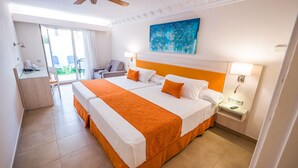 Habitación de hotel con una cama grande, un escritorio y una silla. Hay un cuadro en la pared y una ventana con cortinas.
