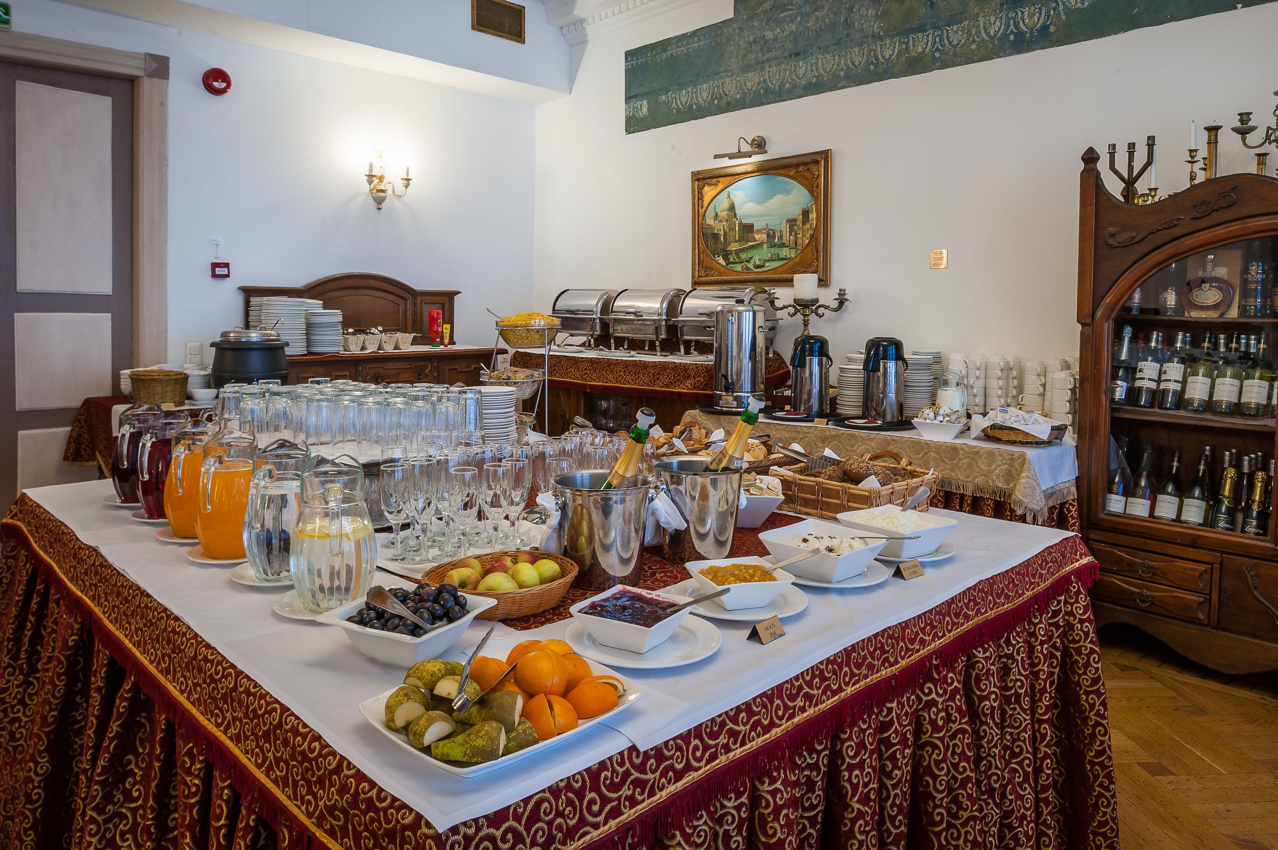 Ein reichhaltiges Buffet mit verschiedenen Speisen und Getränken, darunter Früchte, Säfte und Flaschen.