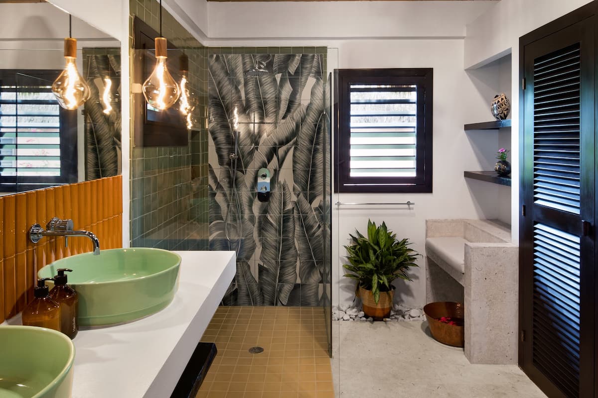 Ein modernes Badezimmer mit zwei grünen Waschbecken, einer Holzbalkendecke und einem großen Spiegel.