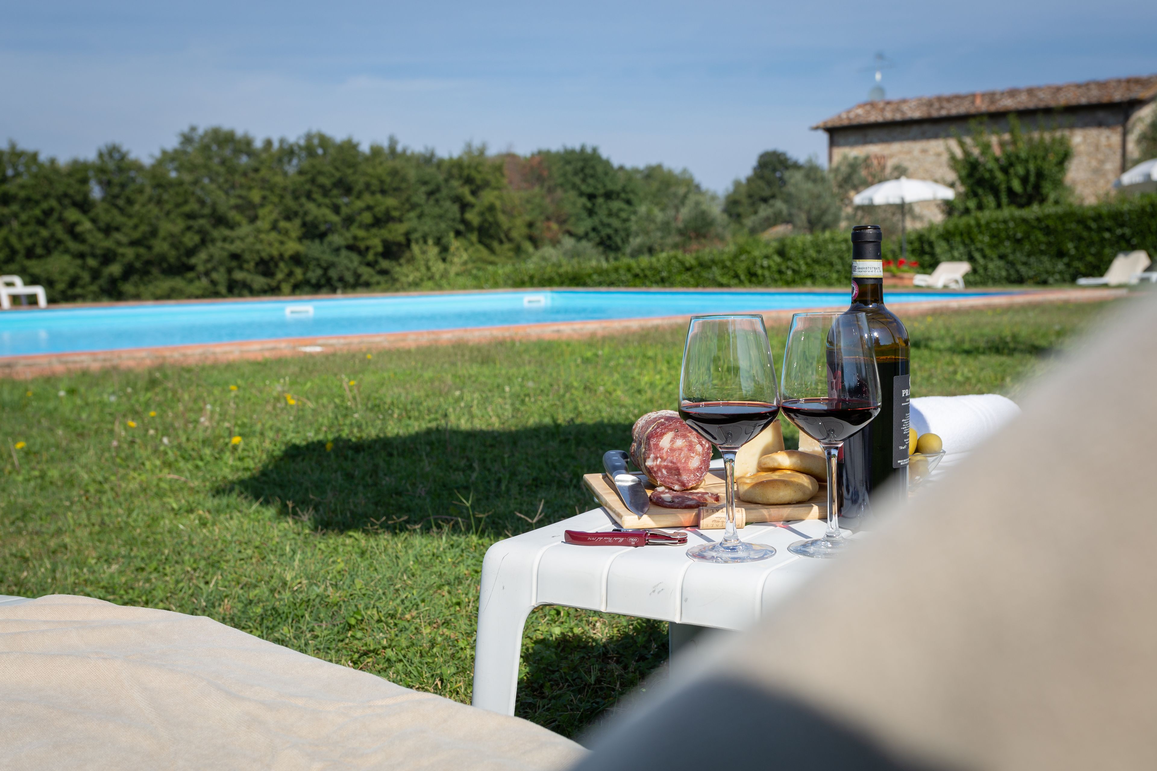 Een buitenzwembad, parasols bij het zwembad en ligstoelen