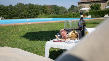 Een buitenzwembad, parasols bij het zwembad en ligstoelen