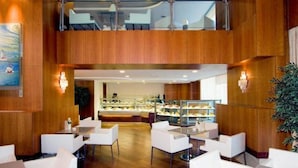 A modern hotel lobby with wooden paneling, white seating, and a glass display case in the background. - Byotell Istanbul (Istanbul)