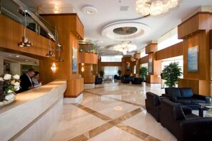 A spacious lobby with a reception desk, seating area, and a large chandelier. - Byotell Istanbul (Istanbul)