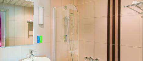 A modern bathroom with two sinks, a bathtub, and a glass-enclosed shower.