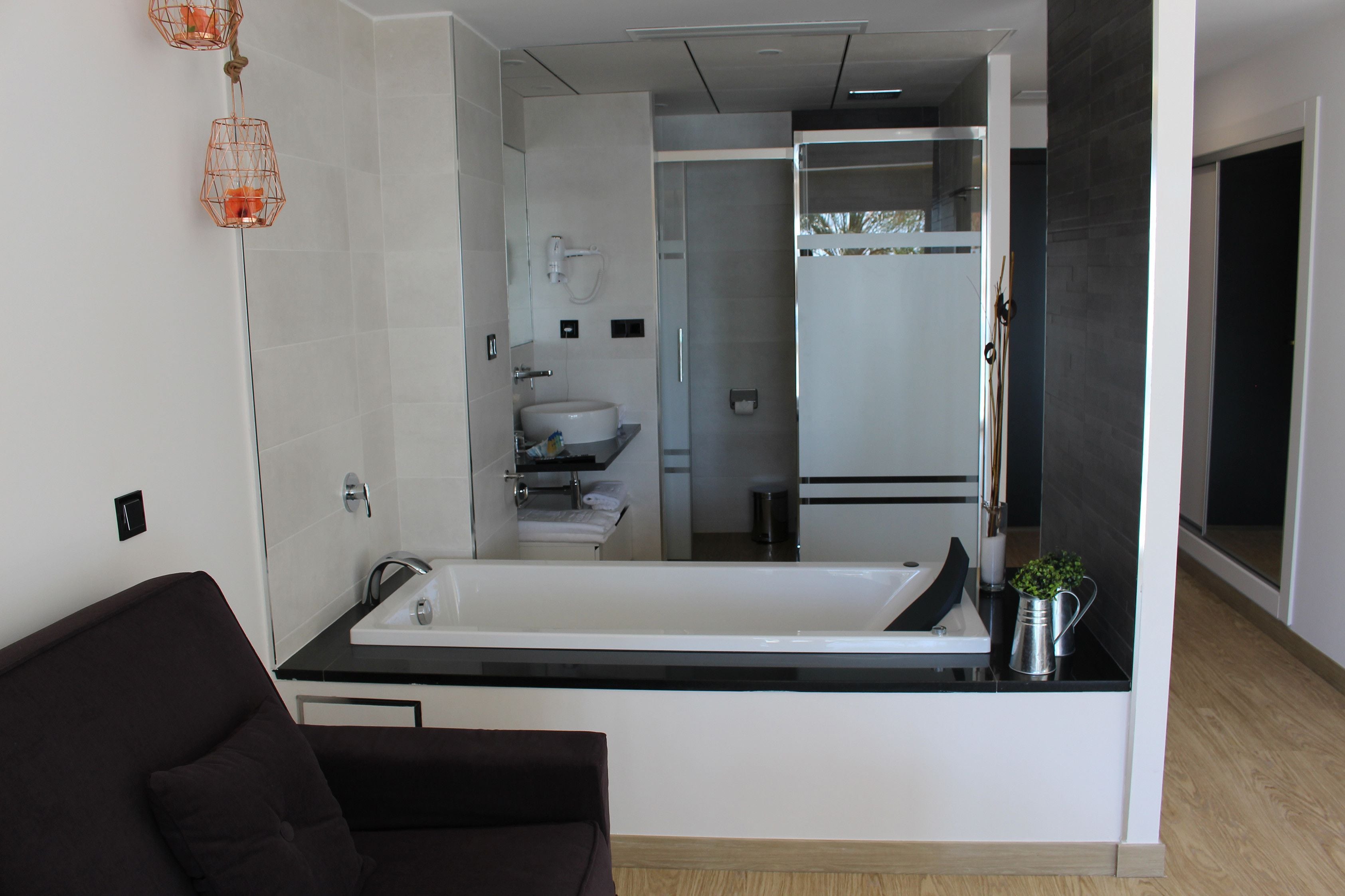 Un baño moderno con una bañera grande, un inodoro y una zona de ducha.