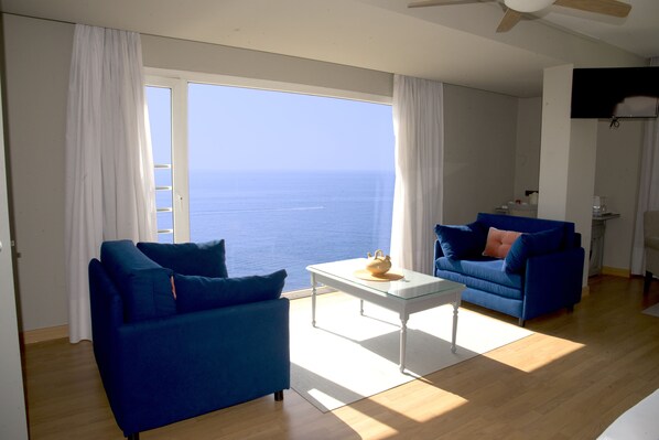 A living room with a sofa, a coffee table, and a view of the sea. - Playadulce Hotel (Aguadulce)