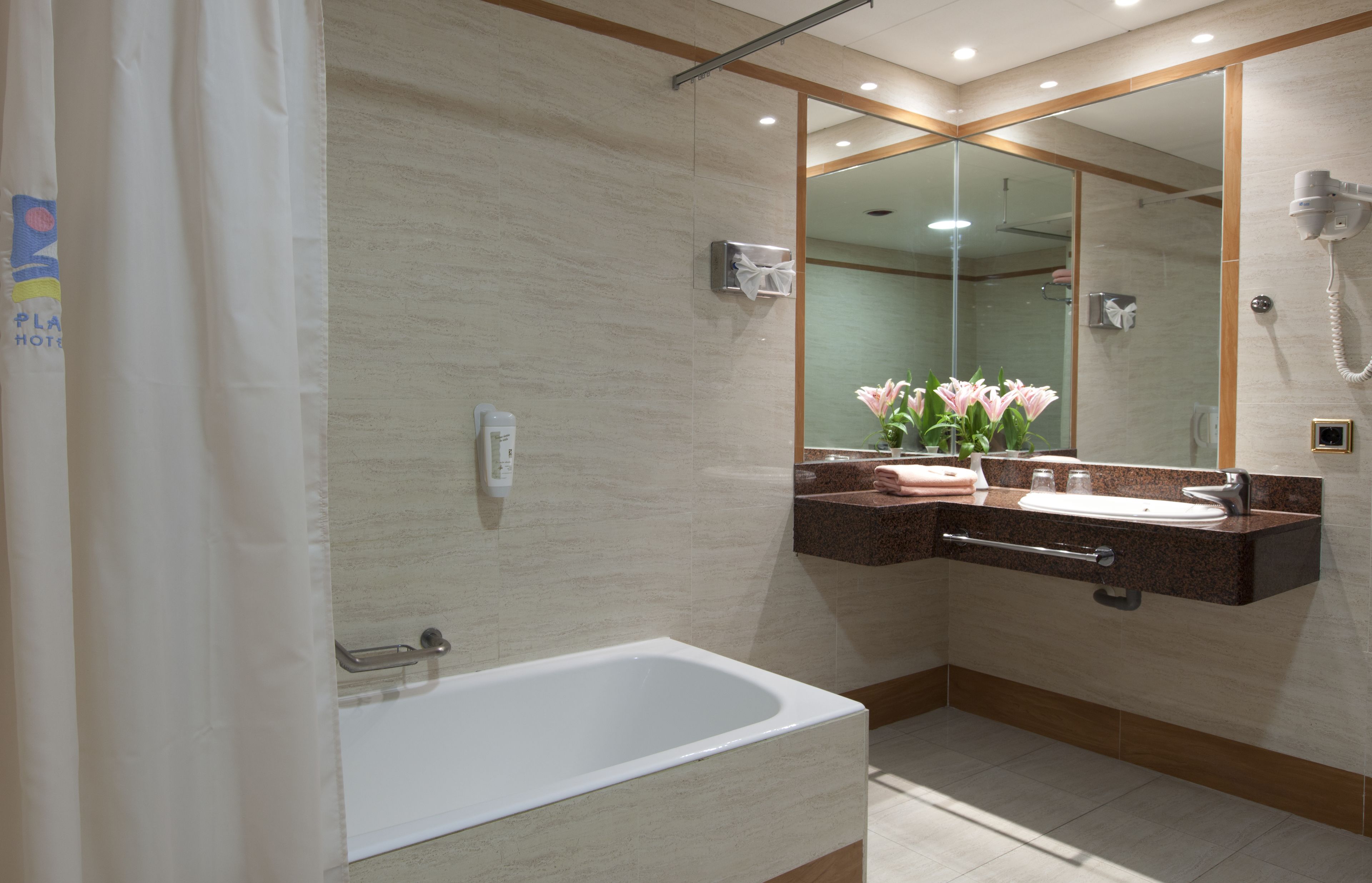 Un baño moderno con bañera, tocador con espejo y ducha.